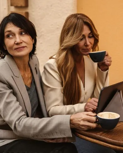 Două prietene stau de vorbă la o cafea